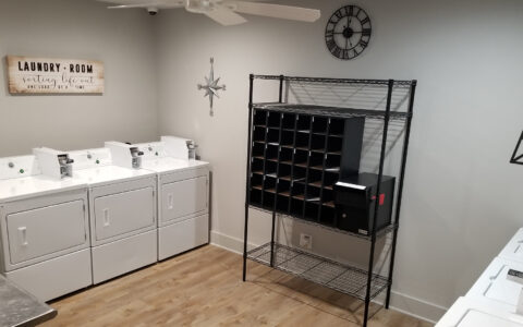 Our laundry room features three commercial washers, three commercial dryers, folding table, laundry cart, and mail station.